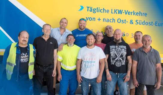 Group photo of transport employees in front of the truck