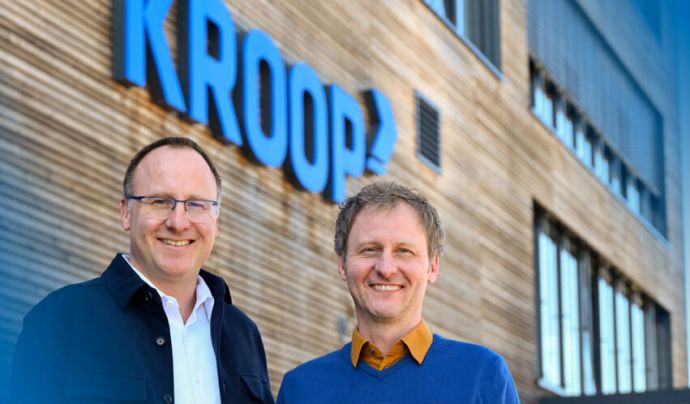 Kroop Leitgedanke Geschäftsführer vor Kroop-Logo